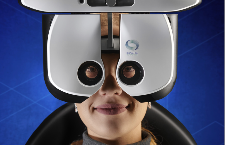 Frau mit Brille in einem Sehtestgerät, lächelt freundlich.